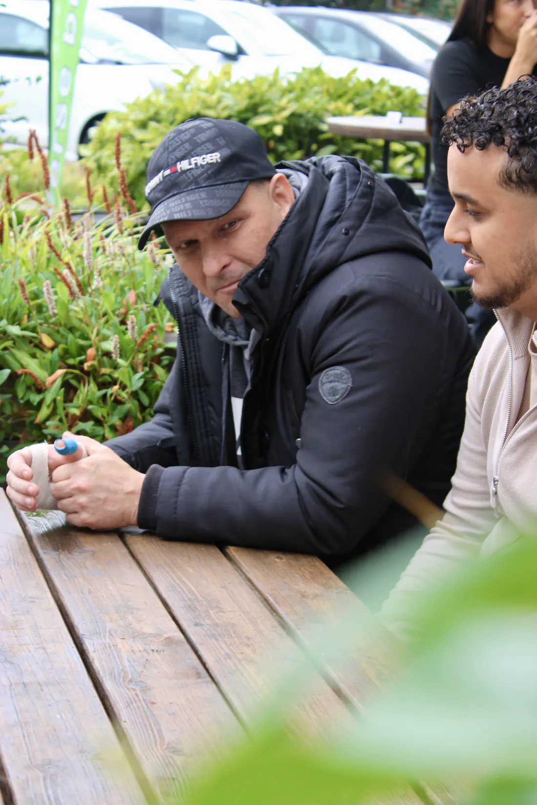 Begeleider en cliënt in gesprek aan een tafel buiten