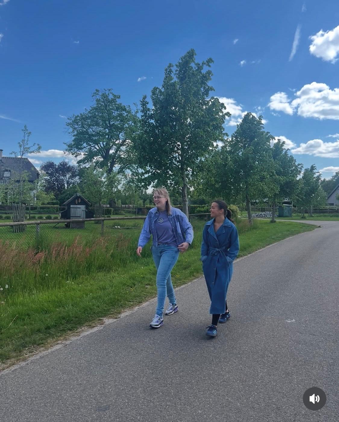 Begeleider en cliënt wandelen samen buiten